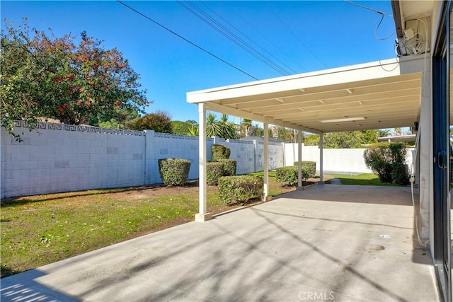 view of patio / terrace with a carport and a fenced backyard