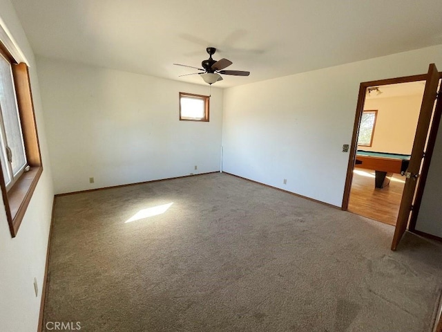 empty room featuring pool table, carpet flooring, baseboards, and ceiling fan