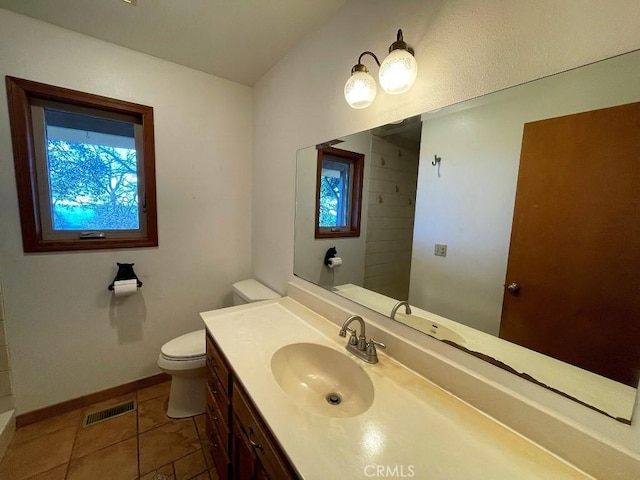 bathroom with vanity, baseboards, tile patterned flooring, toilet, and visible vents