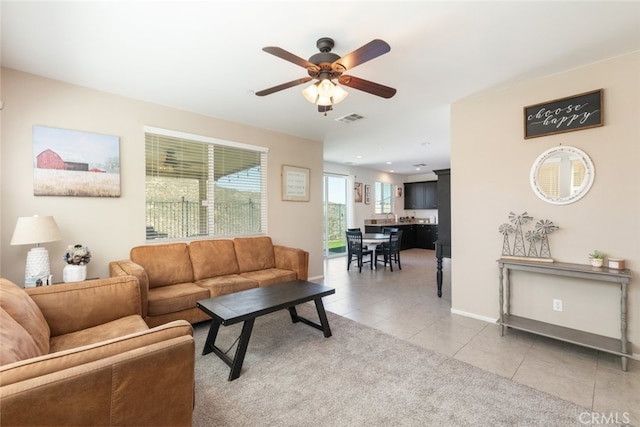 living room with visible vents, ceiling fan, light tile patterned floors, and baseboards