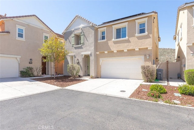 view of front of property with concrete driveway, stucco siding, a garage, and roof mounted solar panels