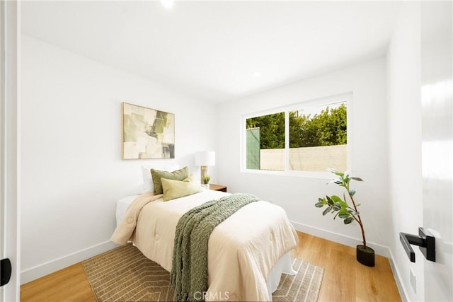bedroom with baseboards and wood finished floors