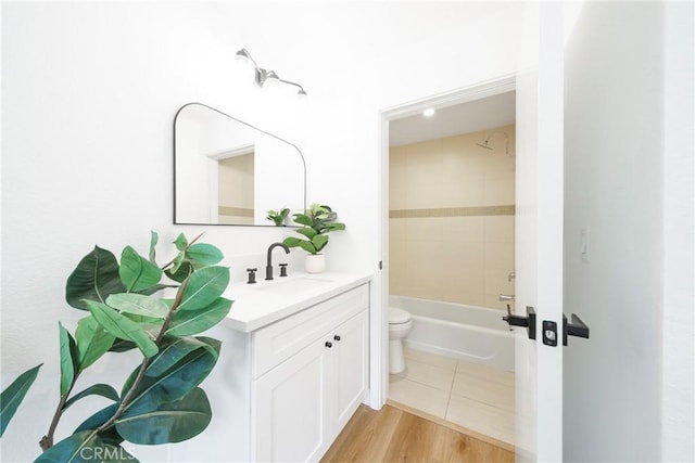 full bath featuring toilet, vanity, wood finished floors, and shower / bathtub combination