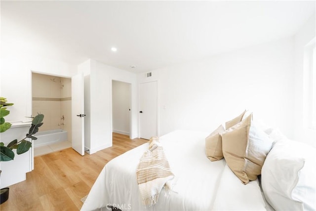 bedroom with wood finished floors, ensuite bath, visible vents, and recessed lighting