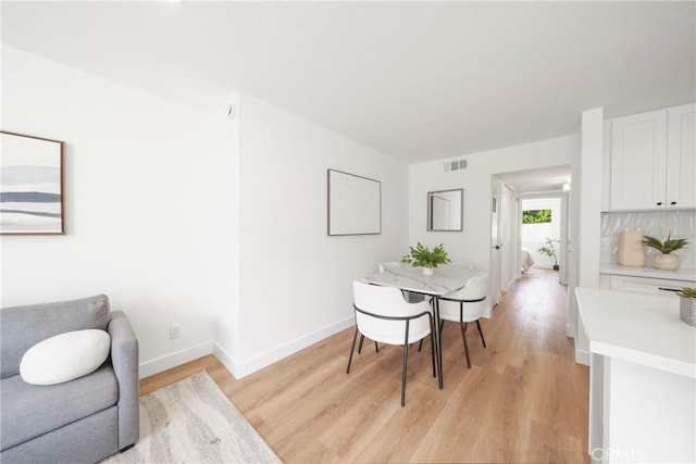 dining area with visible vents, baseboards, and light wood-style floors