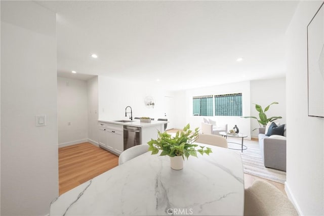 dining room with recessed lighting, light wood-style floors, and baseboards