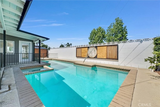 view of pool with a pool with connected hot tub, a patio area, and fence