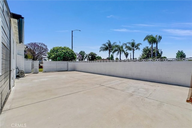 view of patio featuring fence and a gate