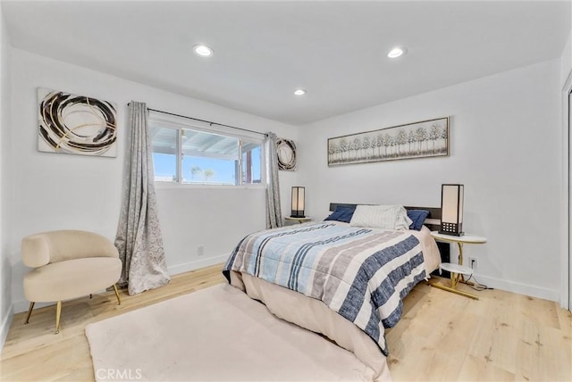 bedroom with wood finished floors, baseboards, and recessed lighting