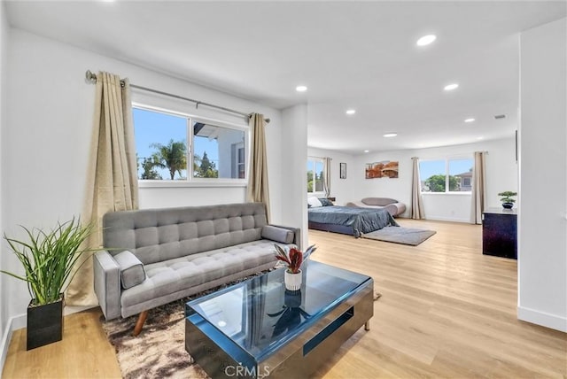 living room with recessed lighting, light wood-style floors, and baseboards