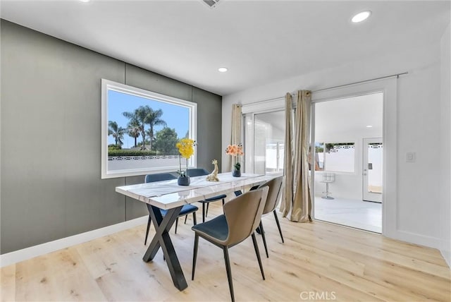 dining space with baseboards, light wood finished floors, and recessed lighting