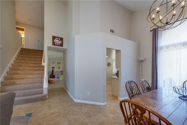 dining room with a high ceiling, visible vents, baseboards, and plenty of natural light