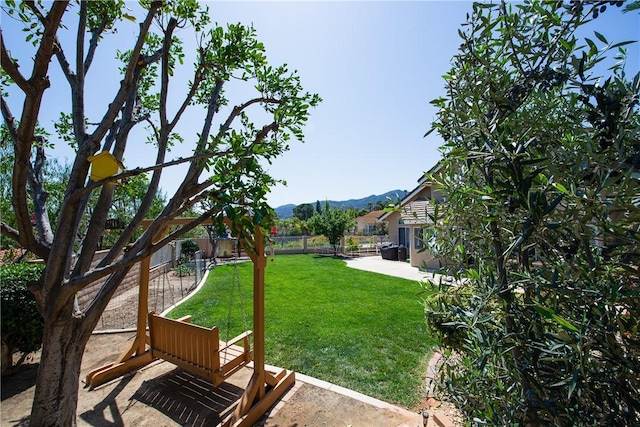 view of yard with fence, a patio area, and a mountain view