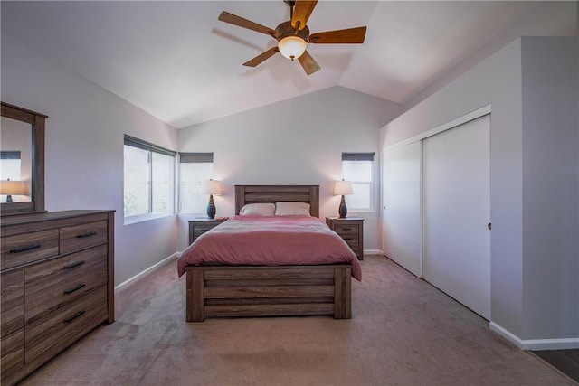 carpeted bedroom featuring ceiling fan, a closet, baseboards, and lofted ceiling