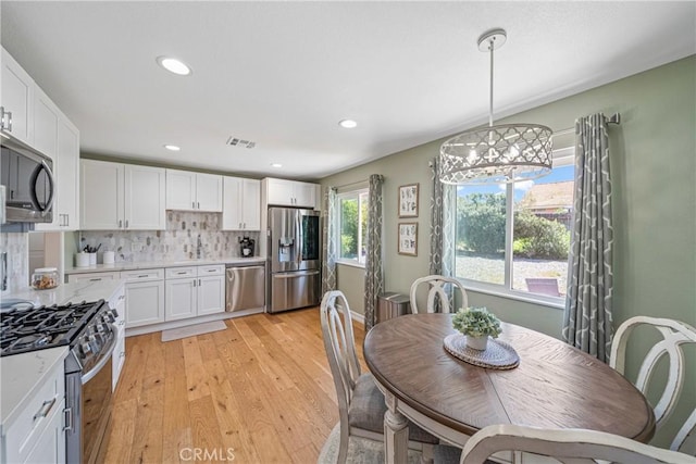 29251 Pebble Beach Dr, Menifee, CA 92586 - dining room featuring recessed lighting, light wood-type flooring, visible vents, and an inviting chandelier