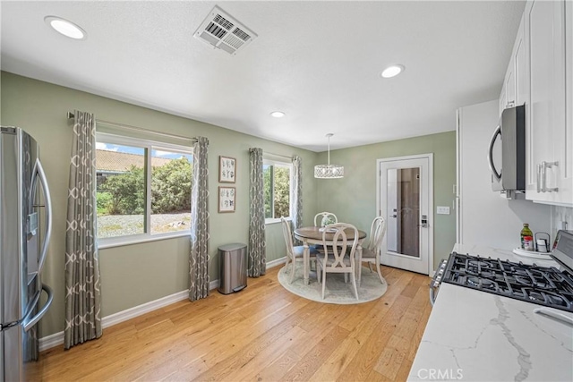 29251 Pebble Beach Dr, Menifee, CA 92586 - kitchen with white cabinets, stainless steel appliances, visible vents, and light wood-type flooring