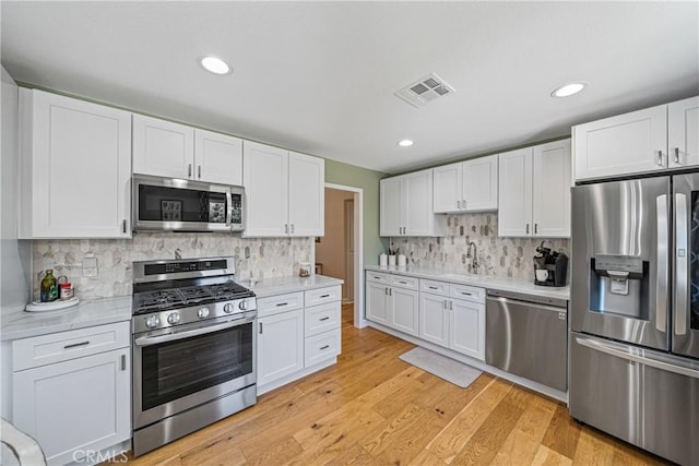 29251 Pebble Beach Dr, Menifee, CA 92586 - kitchen featuring white cabinets, stainless steel appliances, light countertops, and visible vents