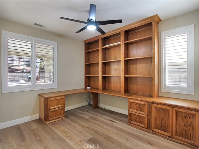 unfurnished office with visible vents, built in study area, a wealth of natural light, and light wood-style floors