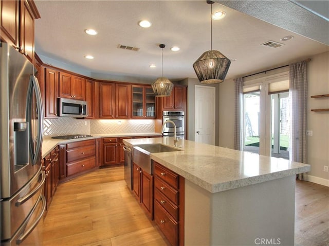 kitchen featuring a sink, visible vents, appliances with stainless steel finishes, and light wood-style floors