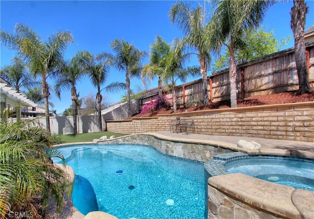 view of swimming pool with a fenced backyard, a fenced in pool, and an in ground hot tub