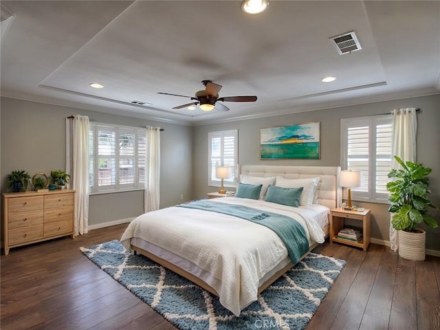 bedroom featuring visible vents, baseboards, ornamental molding, and dark wood finished floors