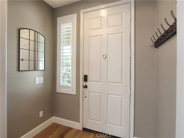 entryway with wood finished floors and baseboards
