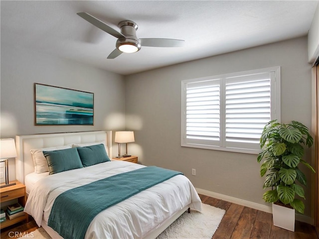 bedroom featuring ceiling fan, baseboards, and wood finished floors