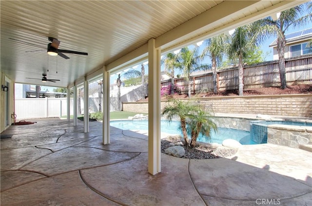 view of patio / terrace featuring a pool with connected hot tub, a fenced backyard, and a ceiling fan