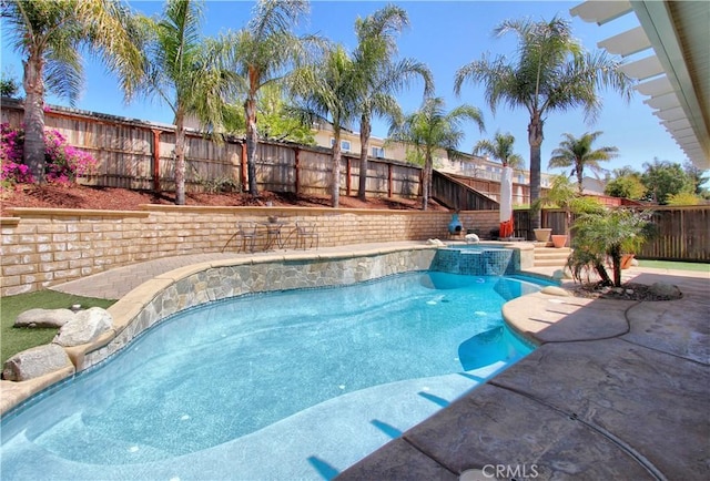 view of pool featuring a patio, a pool with connected hot tub, and a fenced backyard