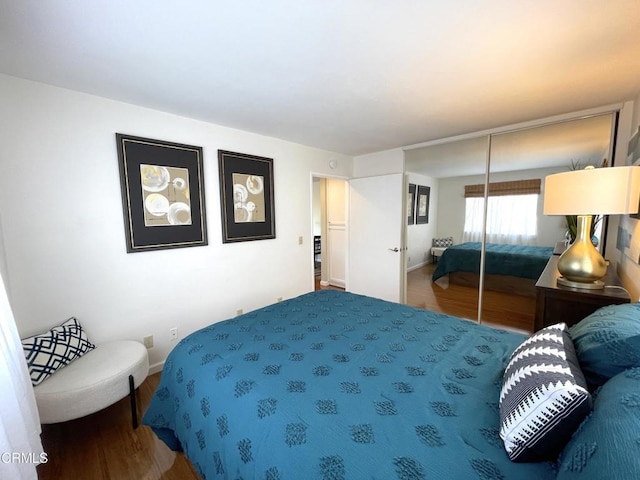 bedroom with a closet, baseboards, and wood finished floors