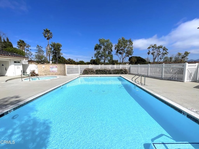 community pool with a community hot tub, a patio area, and fence