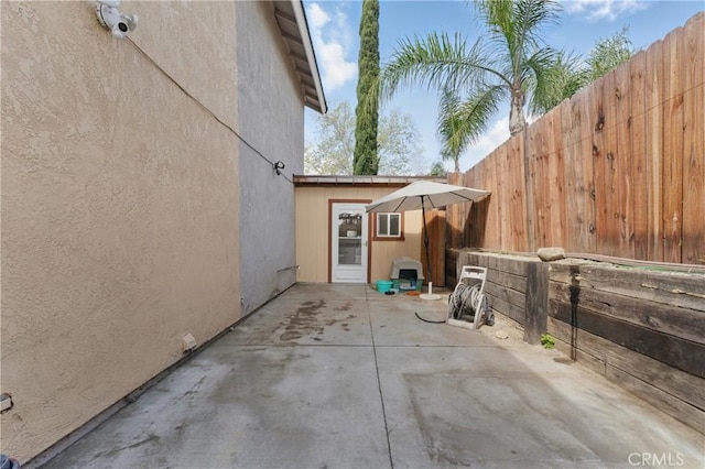 view of property exterior with a patio area, stucco siding, and fence