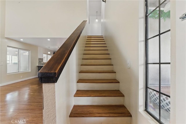 staircase featuring recessed lighting, baseboards, and wood finished floors