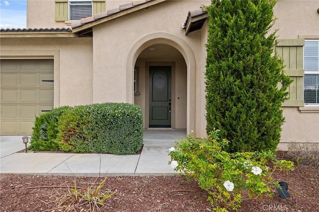 view of exterior entry featuring a tile roof and stucco siding