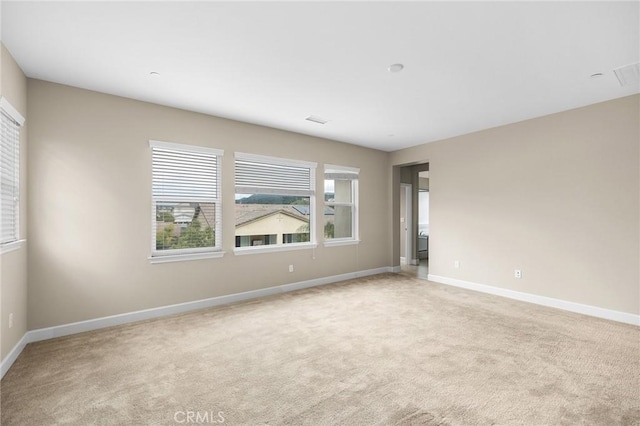 empty room with light colored carpet and baseboards