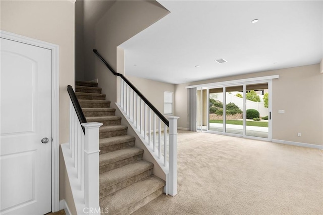 staircase with baseboards and carpet