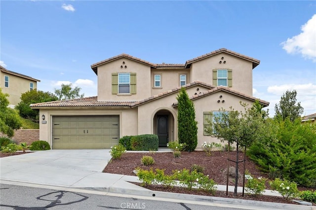 mediterranean / spanish-style home with a tile roof, concrete driveway, and stucco siding