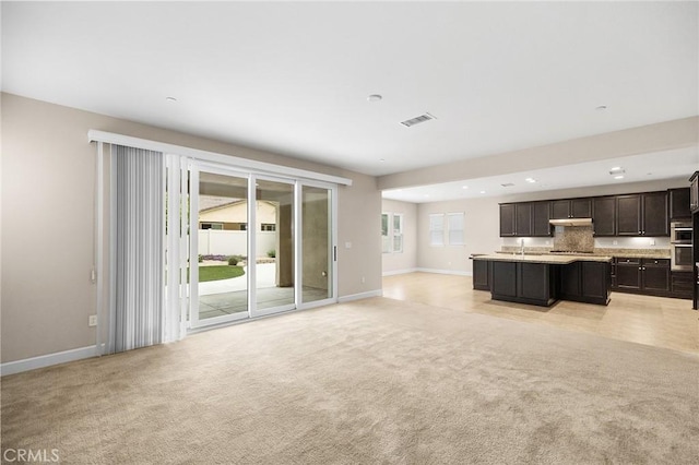 unfurnished living room featuring light colored carpet, baseboards, visible vents, and recessed lighting