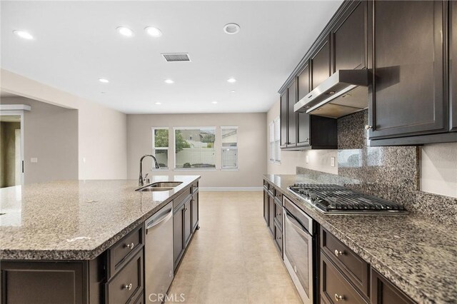 kitchen with a sink, visible vents, baseboards, under cabinet range hood, and appliances with stainless steel finishes