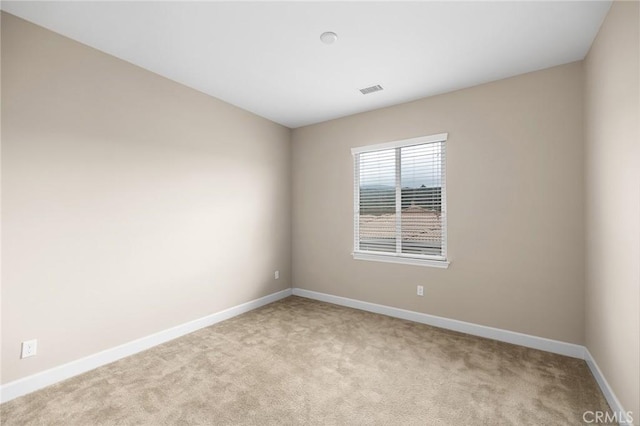 unfurnished room featuring baseboards and light colored carpet