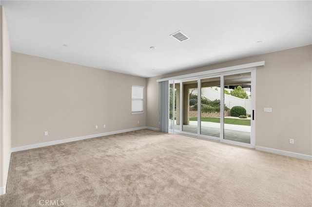 spare room featuring baseboards, carpet flooring, and plenty of natural light
