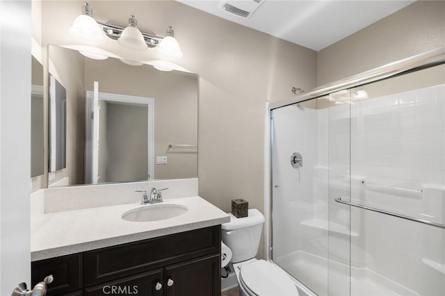 bathroom with a shower stall, visible vents, toilet, and vanity