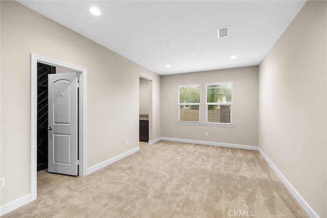 interior space with visible vents, light carpet, baseboards, and recessed lighting