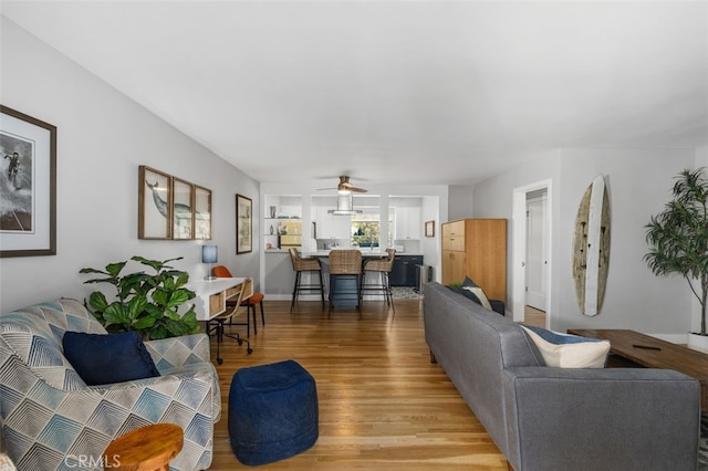 living area with light wood-style floors and ceiling fan