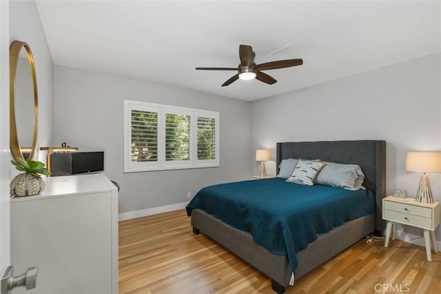 bedroom featuring light wood-style flooring, baseboards, and a ceiling fan
