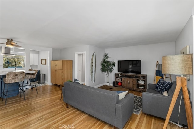 living room with light wood finished floors and ceiling fan