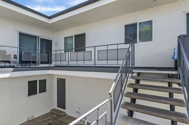entrance to property featuring stucco siding and a balcony