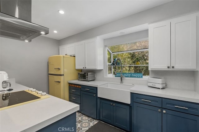 kitchen with extractor fan, a sink, blue cabinetry, white cabinets, and recessed lighting
