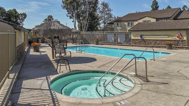 pool featuring fence, a patio, a gazebo, and a community hot tub
