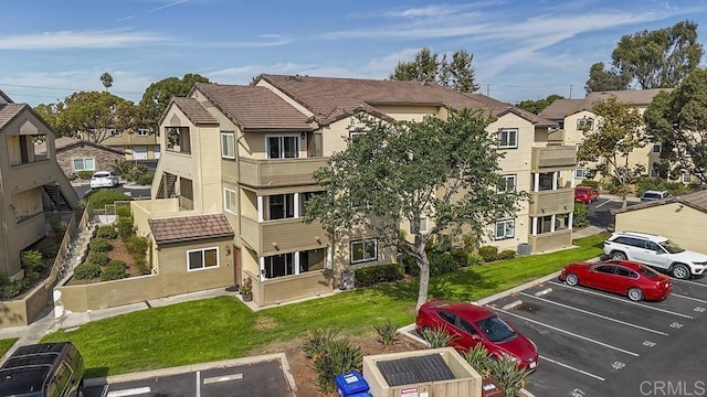 view of property with uncovered parking and a residential view